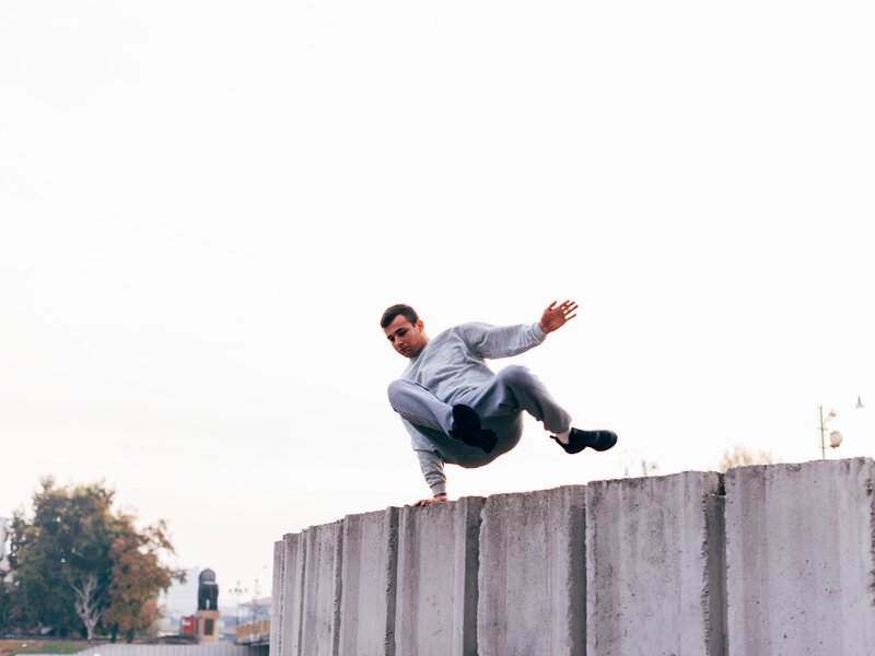 Caucasian man trains parkour while jumping over a high top. | © Â©Dimco - stock.adobe.com